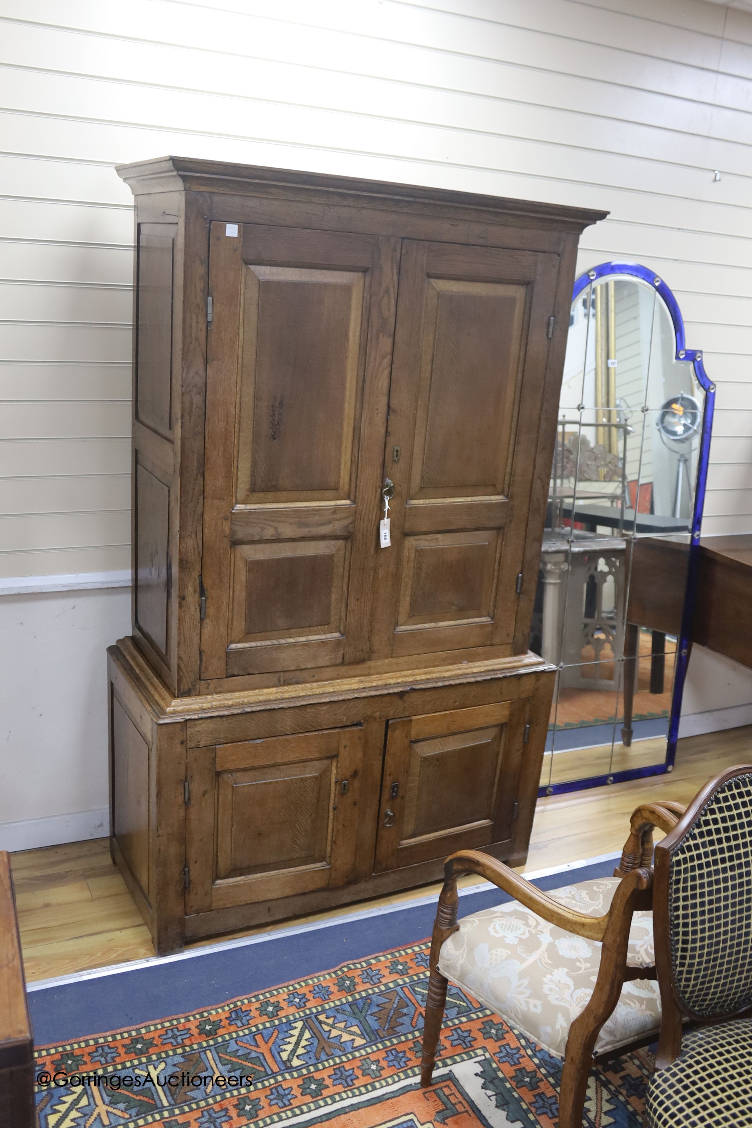 An early 18th century panelled oak press cupboard, dated 1714